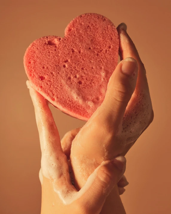 a heart shaped soap bar being held in the palm of someones hand