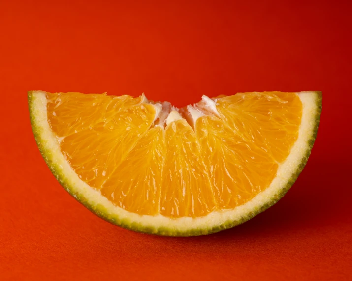 an orange is displayed on an orange background