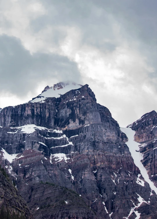 the snow covered mountains are covered in clouds