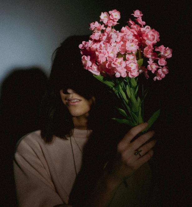 a woman with a bouquet of pink flowers on her head