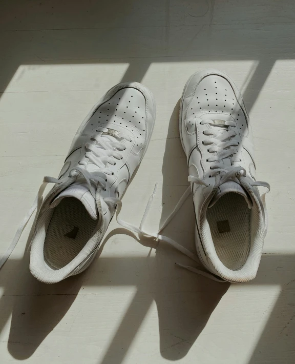 white tennis shoes on top of a white bench