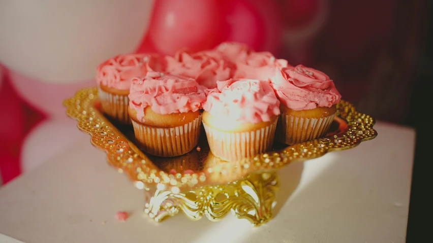 a table topped with lots of cupcakes covered in frosting