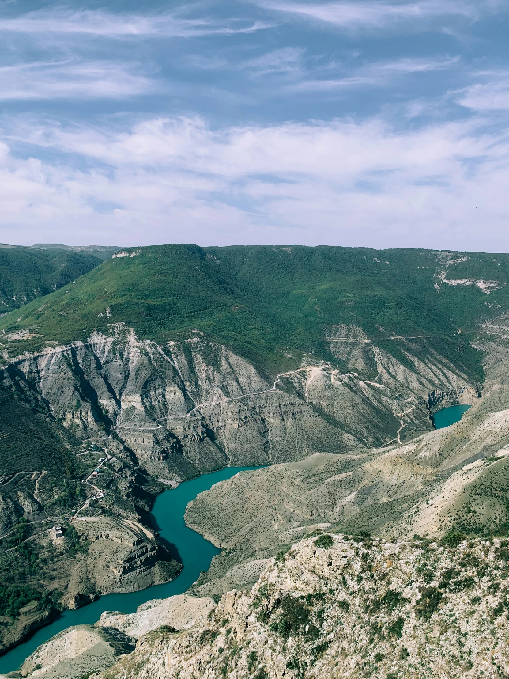 an aerial view of a river running in the hills