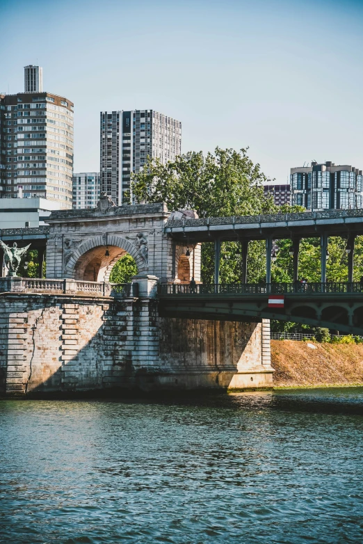 the cityscape is shown next to the river and bridge