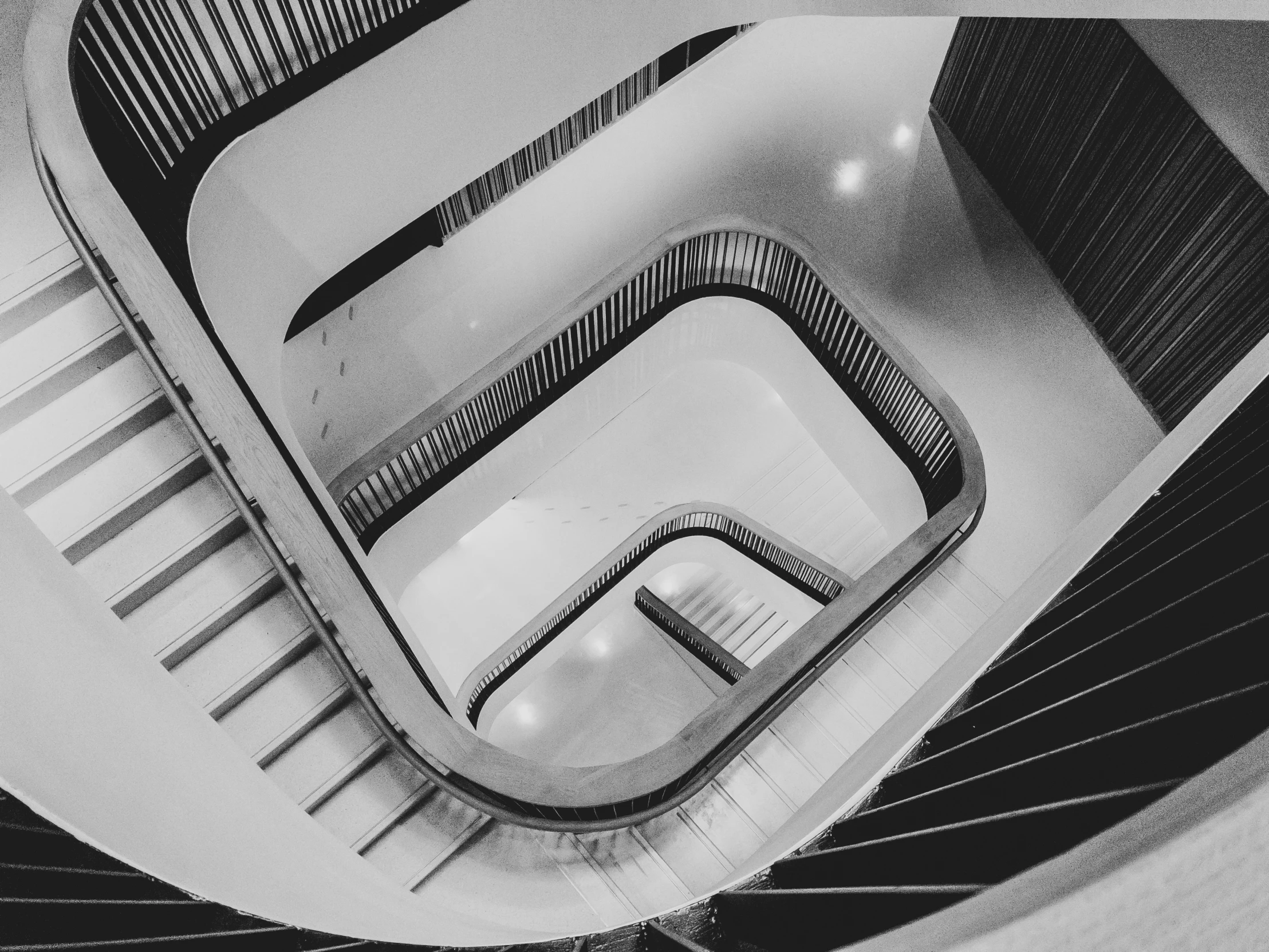 black and white po of stairwell with curved staircase