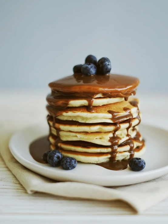 blueberries and pancakes are covered in chocolate syrup