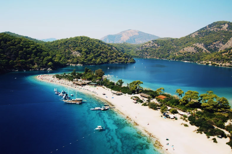 a very long sandy beach surrounded by mountains