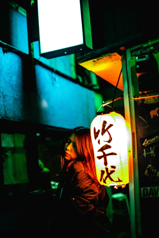 a woman standing by a pole with some asian writing on it