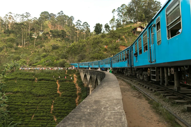 a train carrying people through lush green hills