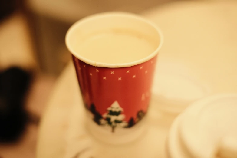 a red cup with white lid on a table