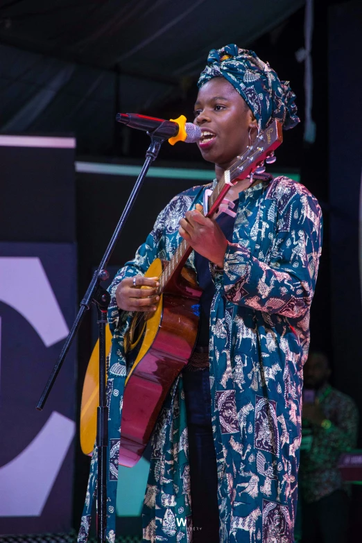 a woman on stage playing an acoustic guitar