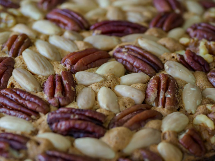 a pie with many pecans on it sitting on a table