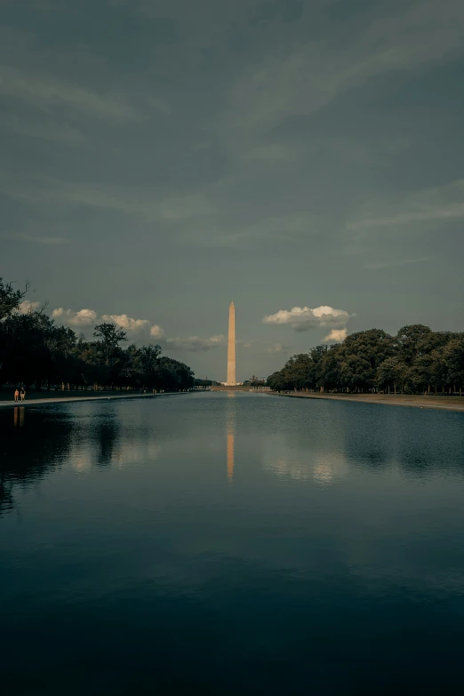 the washington monument, reflecting off a body of water