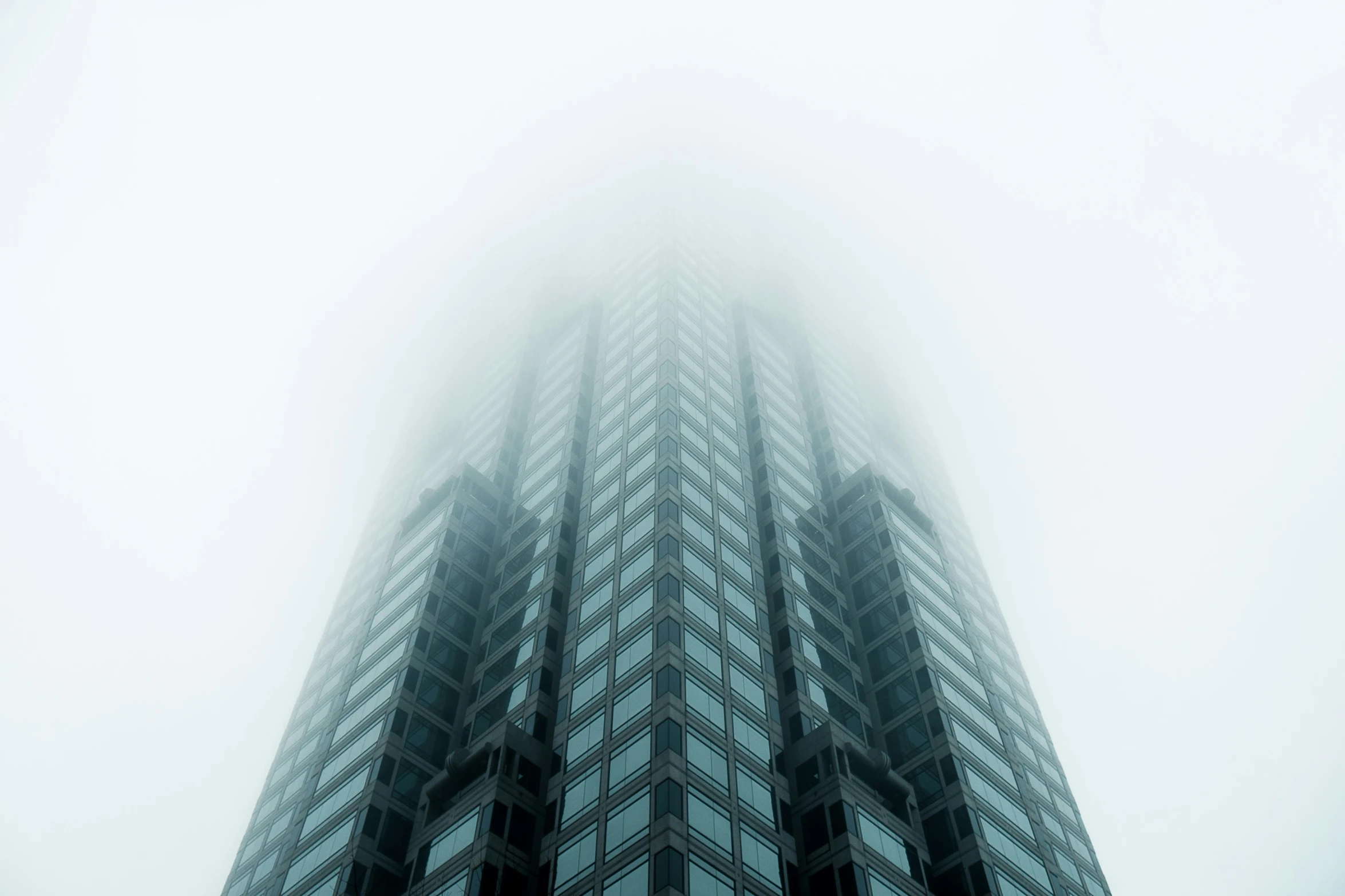 the top of a skyscr building against a foggy sky