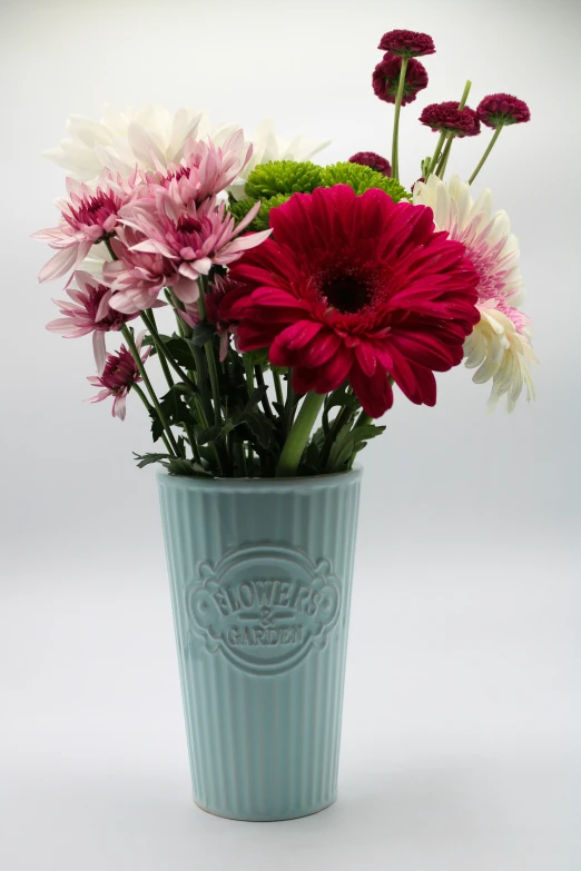 a vase of various colorful flowers on a white background