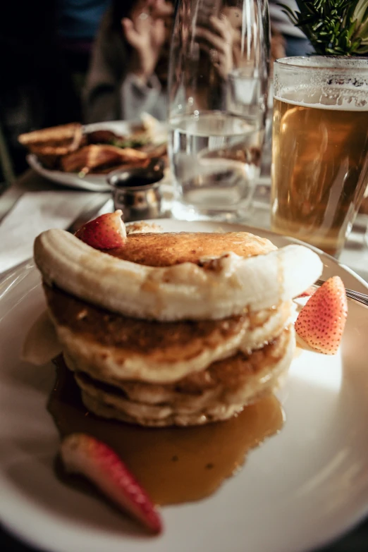 some pancakes and strawberries sitting on a plate