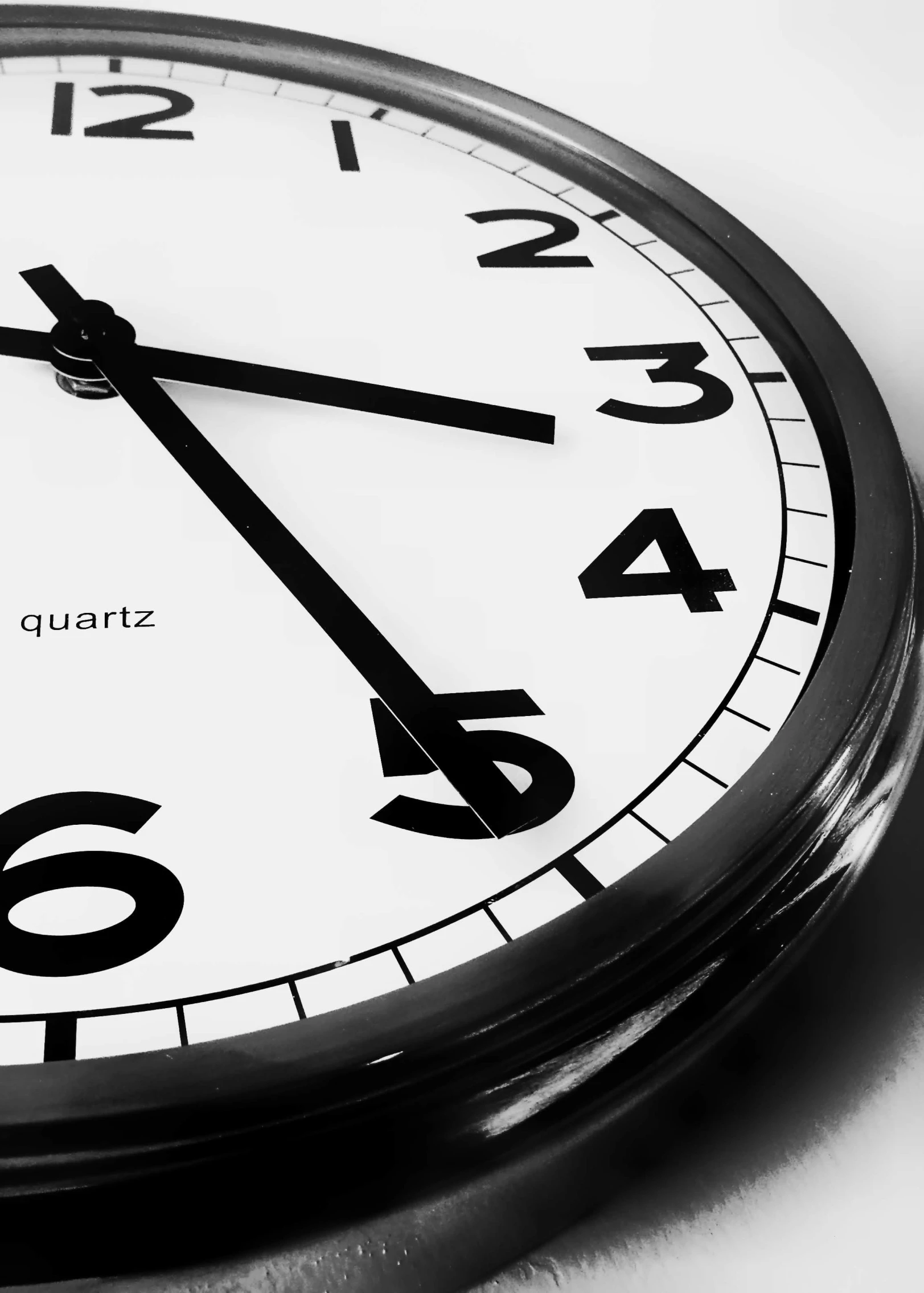 black and white pograph of a clock with the hands showing 11 55