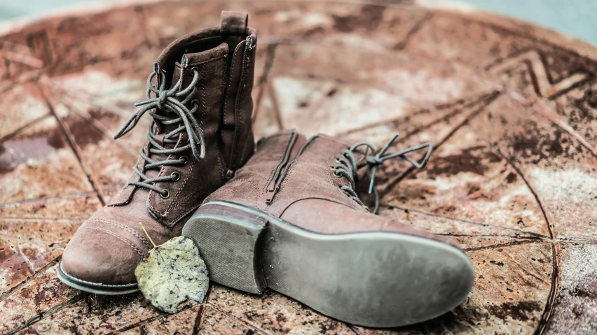 a pair of brown boots sitting on top of a rock