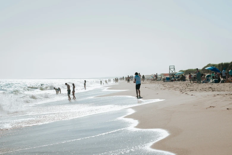 the people are at the beach walking on the sand