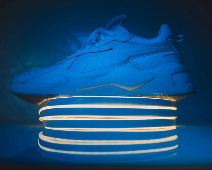 a blue sneaker with white lights shining through the sole
