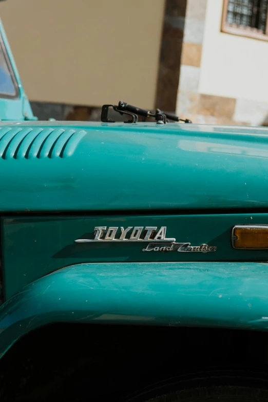 a green jeep parked next to a white building