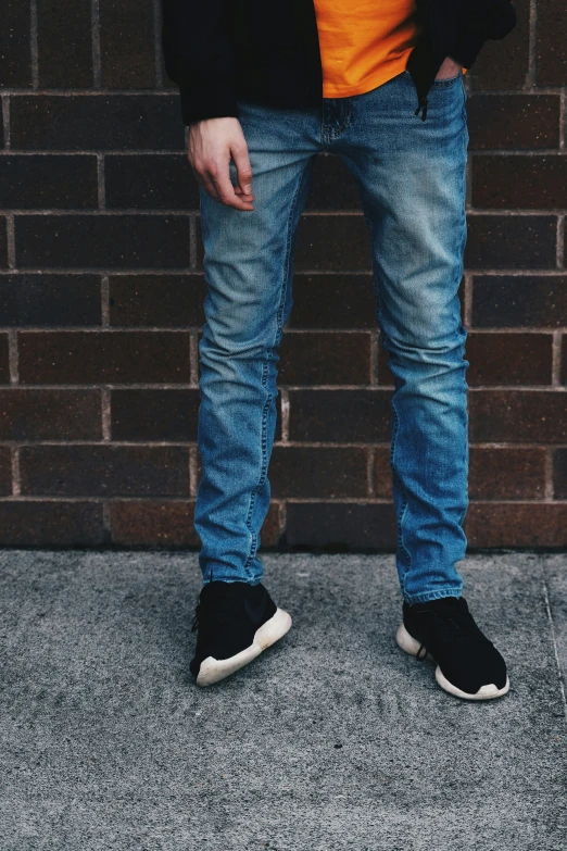 a man wearing a jacket, jeans and black tennis shoes