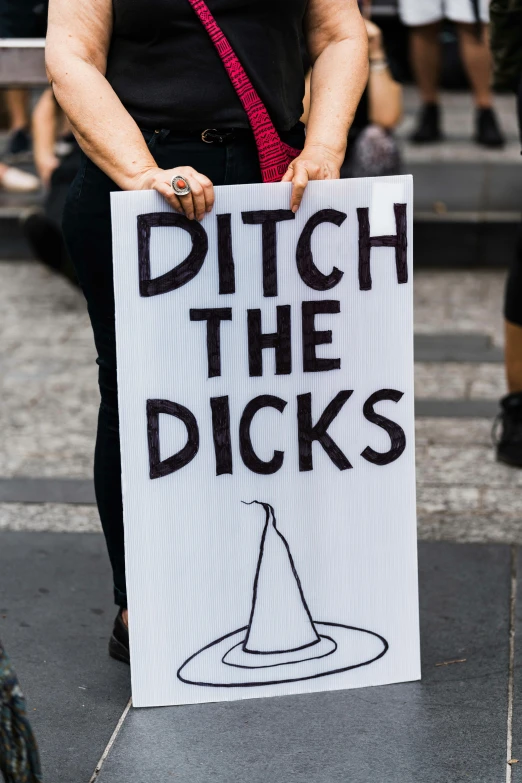 a woman in black shirt holding up a sign