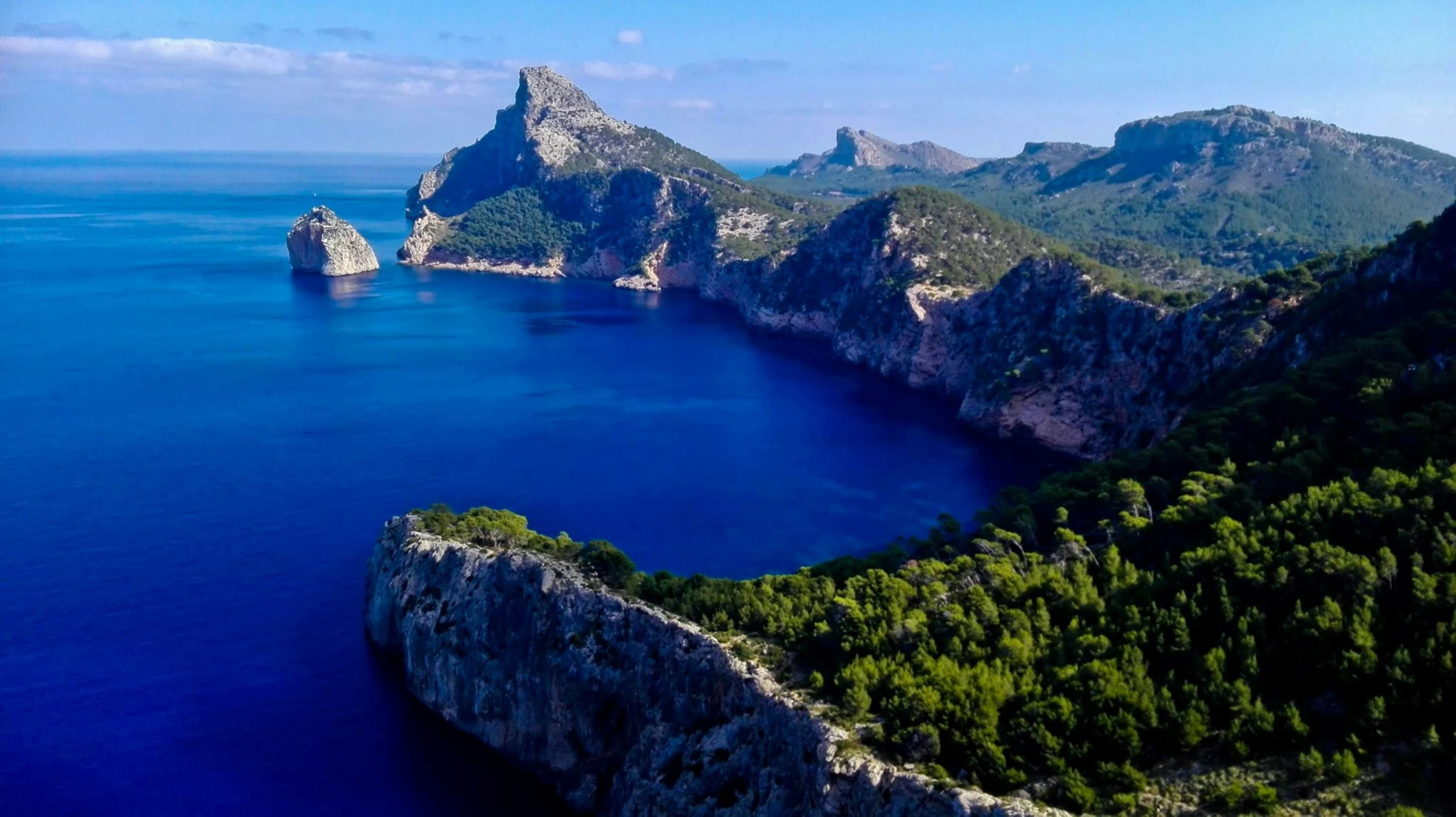 three big mountains in the ocean with some water