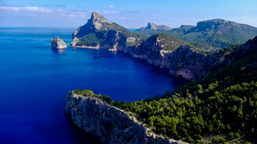 three big mountains in the ocean with some water