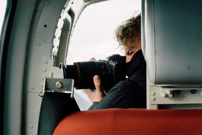 a woman taking a picture with a camera in an aircraft