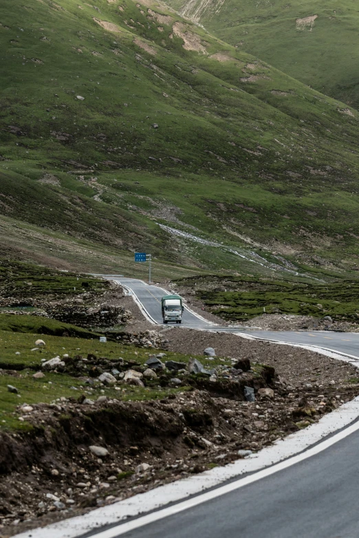 two trucks are traveling down a mountain road