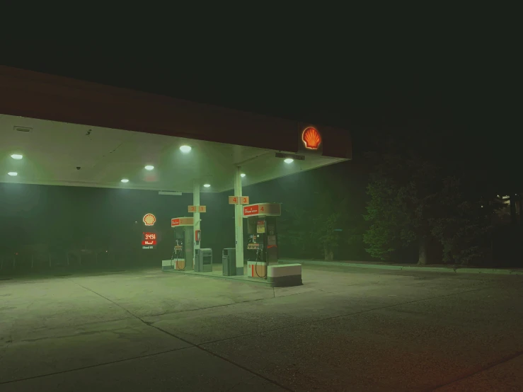 a gas station lit up at night, with the light on