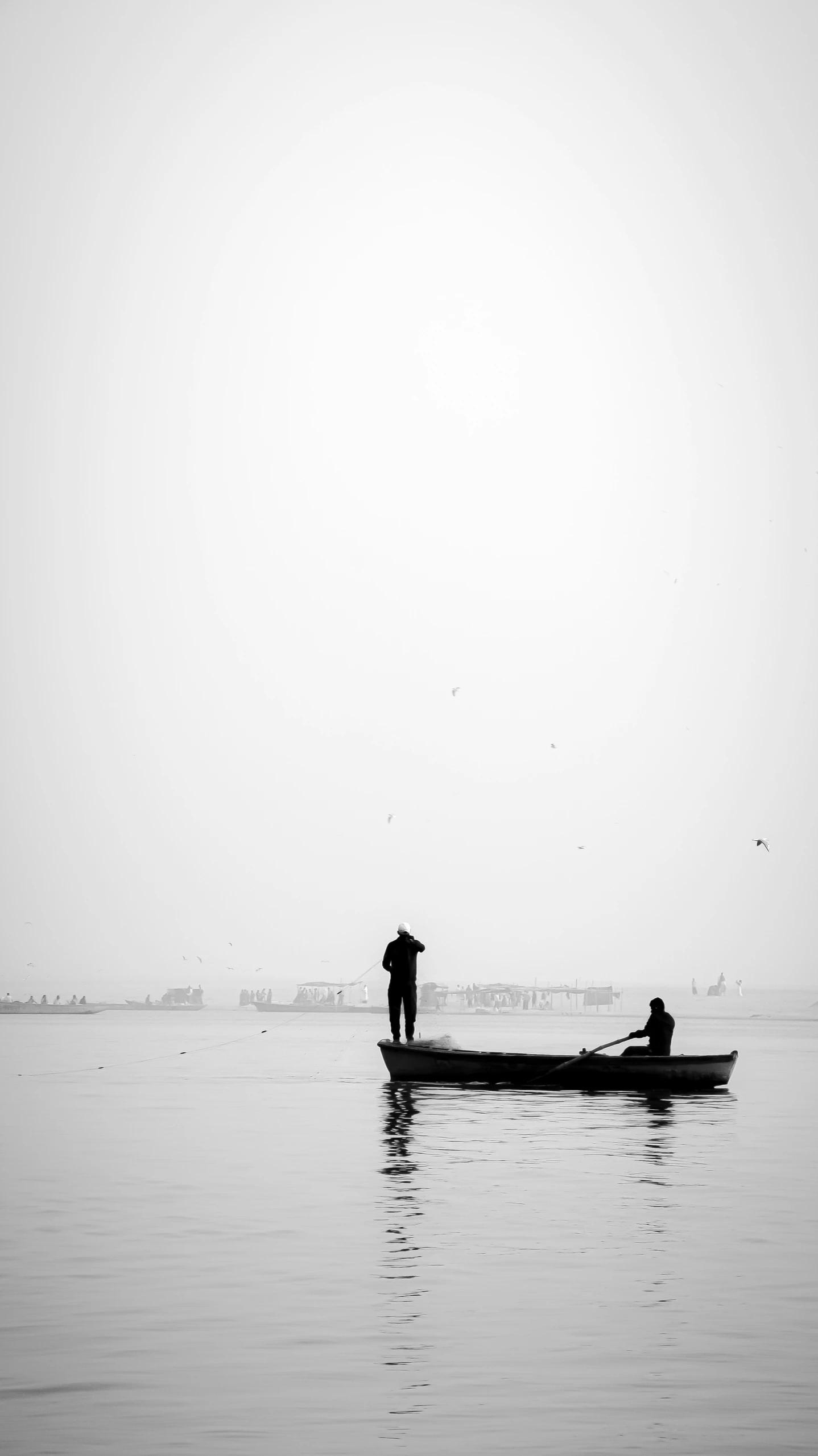 three people in a boat in water with one standing at the end