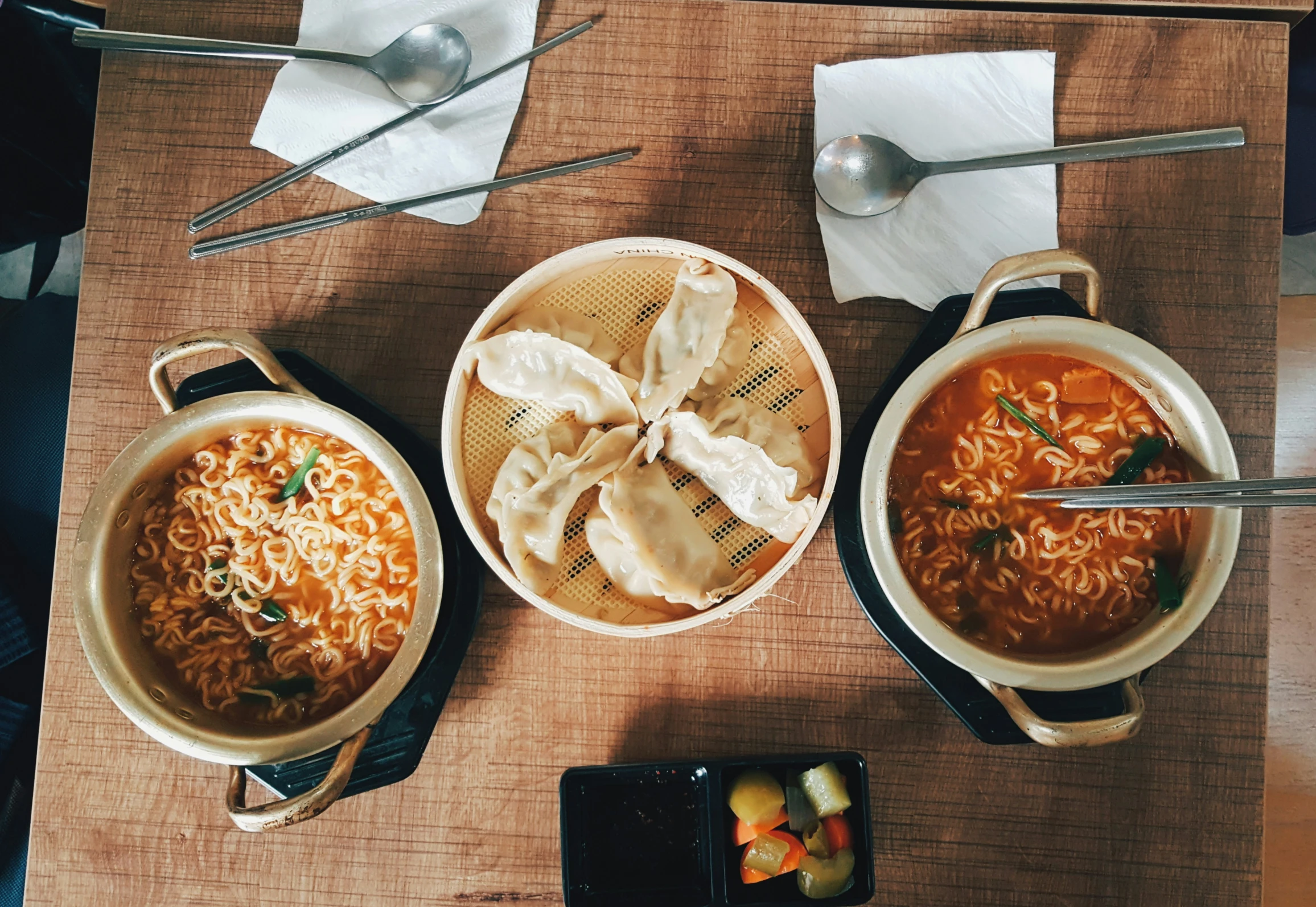 the table has two bowls of soup and two bowls of broth