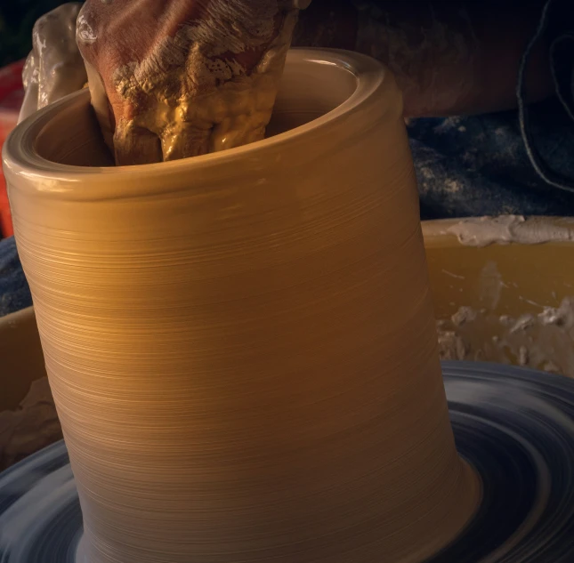 a person's hand on top of a vase