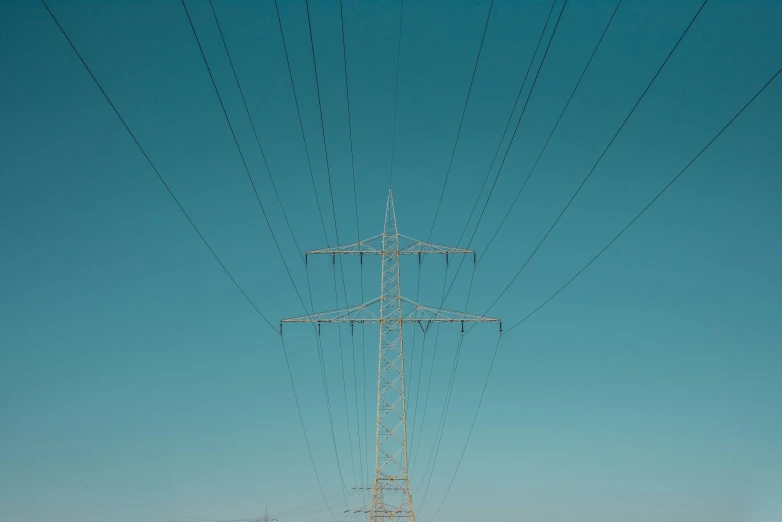 some very large electric poles and wires in the sky