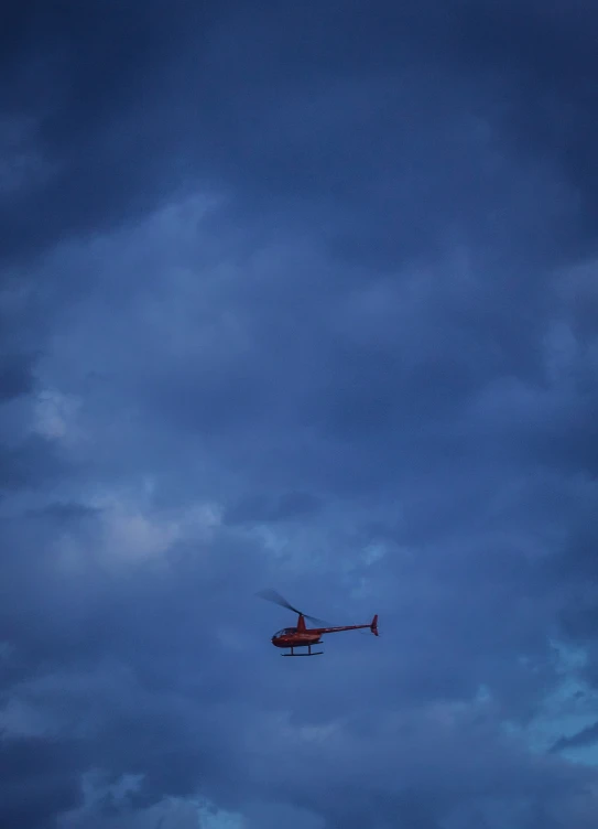 a helicopter is flying high in the dark sky