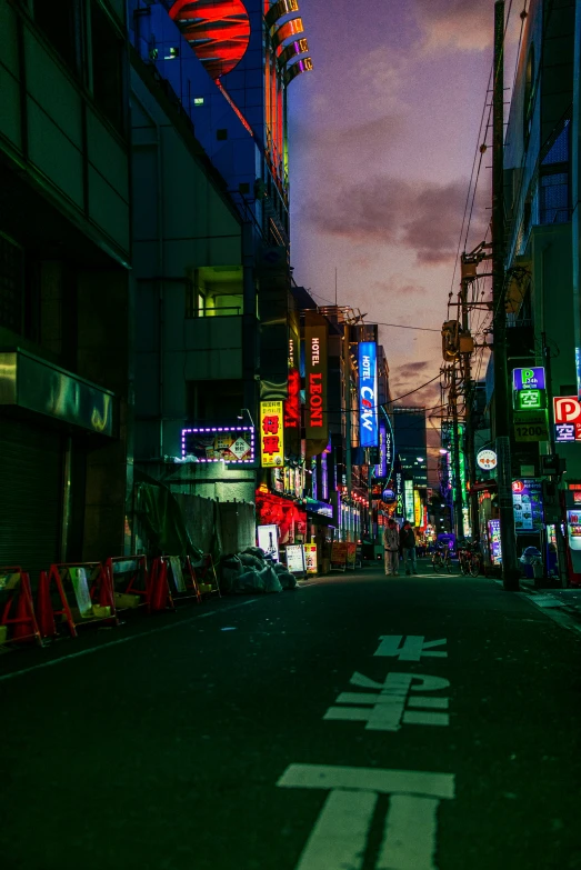 a street in a city at night with buildings in the background