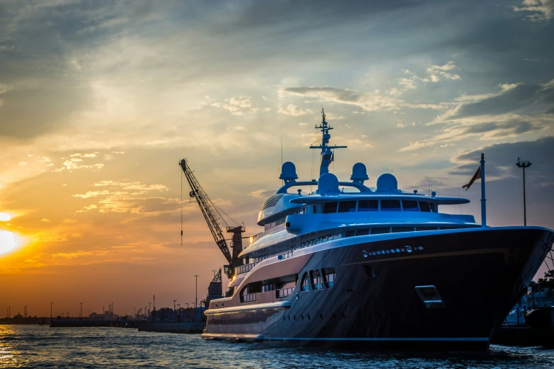 a cruise boat moored in the harbor during sunset