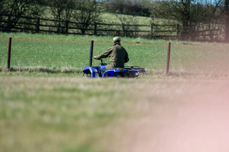 a man rides on an old blue quad
