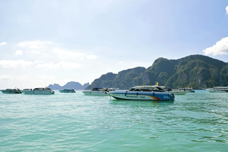 many boats on the water by some mountains