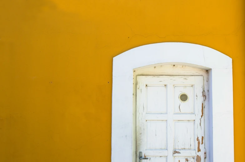 the door to a yellow and white building with a white frame