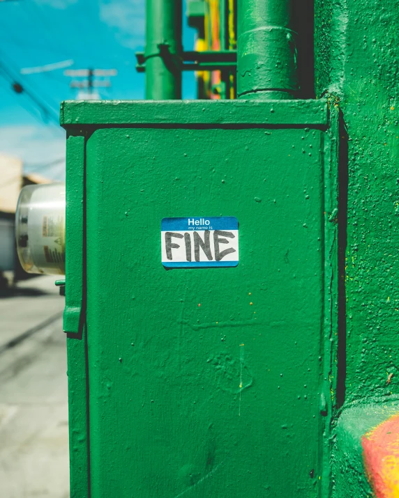 a sticker on the side of a green box that says fine