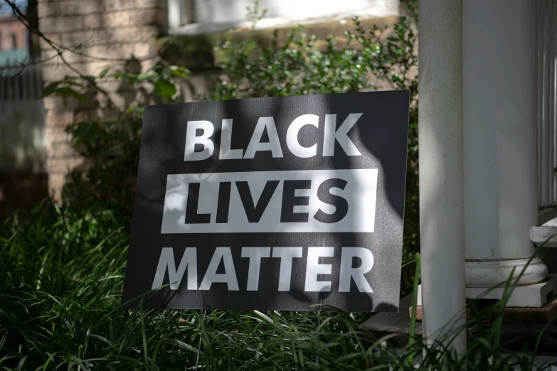 a black lives matter sign sitting in the grass