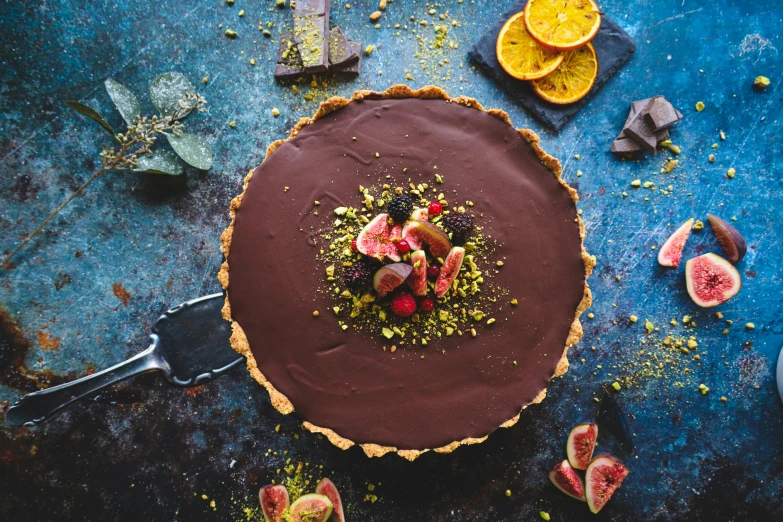 a chocolate tart topped with fresh fruit on top of a table