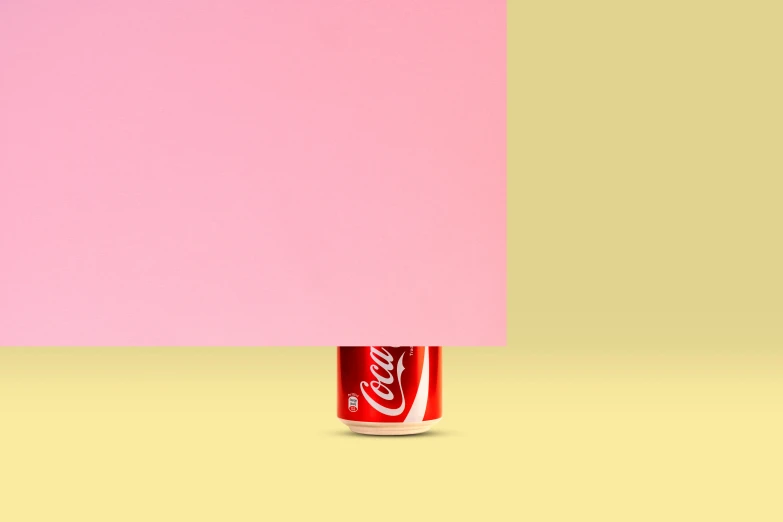 coca cola can standing with one half of it pink