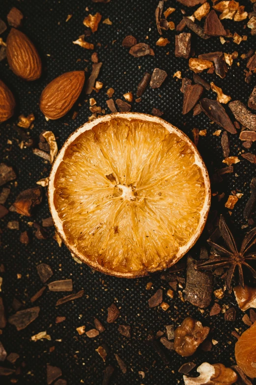 a dried orange on the floor surrounded by nuts