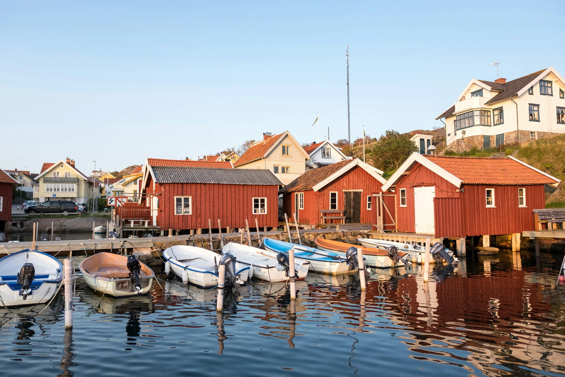 row of houses along the water with boats parked in front