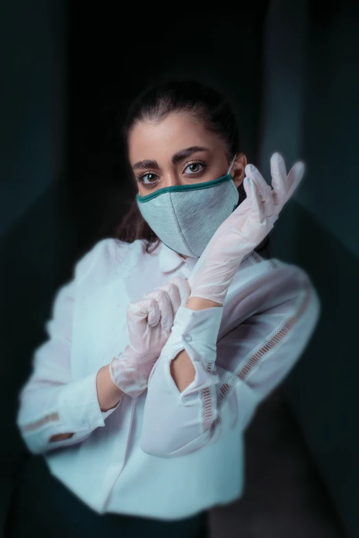 woman in gloves and a mask making hand gestures