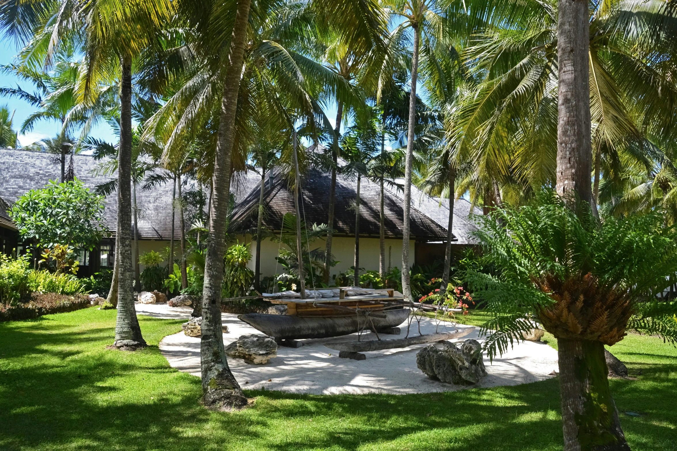 this house is surrounded by palm trees and white stones